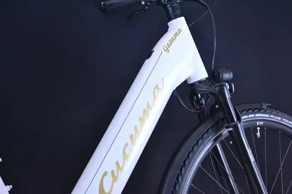 Akku 630Wh Das Trekking E-Bikes Gamma von Cucuma mit Nahaufnahme des goldenen Cucuma Schriftzugs am Rahmen